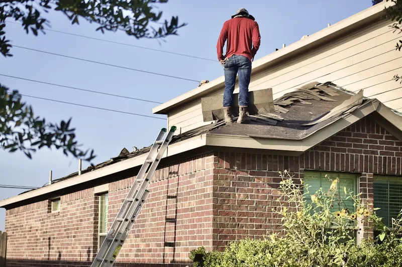 Professional roofer working on a residential roof in Angleton